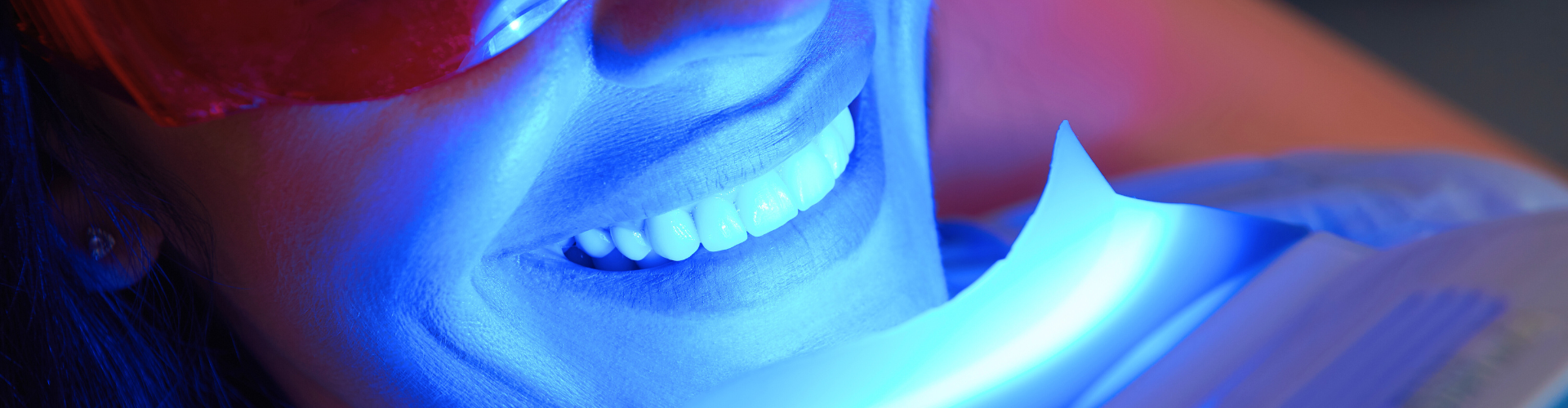 Blue light shining on woman's smile.
